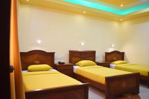 瓜亚基尔Hostal Galápagos - Guayaquil的客房 - 带两张带黄床单的床