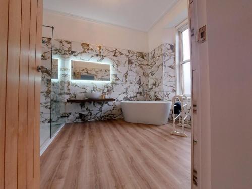威廉堡拉瑞斯通旅馆的浴室配有白色浴缸和镜子
