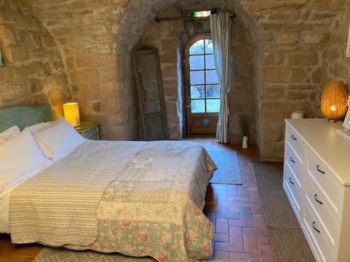 Les AssionsIdyllic French farmhouse的石头建筑中一间带大床的卧室