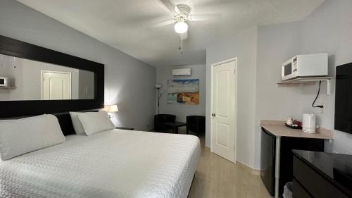 沃思湖白马汽车旅馆 的卧室配有白色的床和微波炉