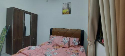 居林Myrol Homestay Kulim的一间卧室配有一张带粉色床单和镜子的床