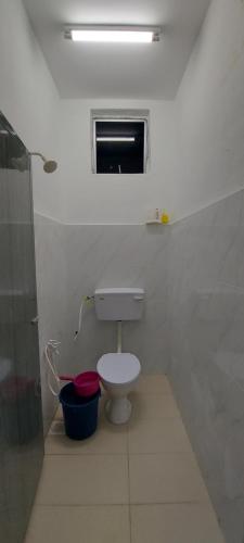 居林Myrol Homestay Kulim的白色的浴室设有卫生间和窗户。