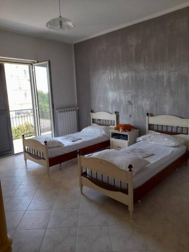 卡萨尔诺沃-迪拿波里Appartamento con parcheggio gratuito all'interno的带窗户的客房内的三张床