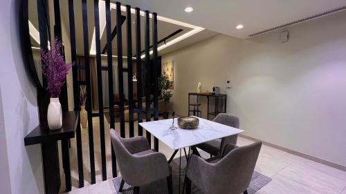 马斯喀特Luxury apartment in Muscat Hills的一间配备有白色桌椅的用餐室