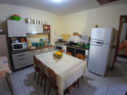 大塞拉Maravilhosa praia do Sargi - BA的厨房配有桌子和白色冰箱。