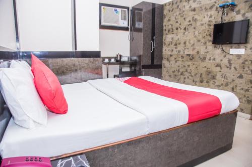 阿加尔塔拉OYO Hotel Executive Inn的一张带红色和白色枕头的床