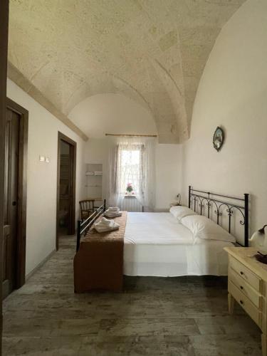 佩兹迪格雷科L'Antico Camino的卧室设有一张白色大床和一扇窗户。