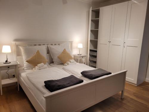 哈根Stadthaus nahe Fußgängerzone的卧室配有一张带两个枕头的大白色床
