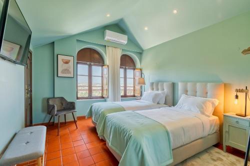 塞图巴尔Villa Casal Assis的一间卧室配有两张床和椅子