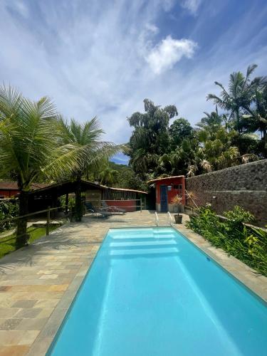 坎布里Aldeia de Camburi的房子前面的蓝色游泳池