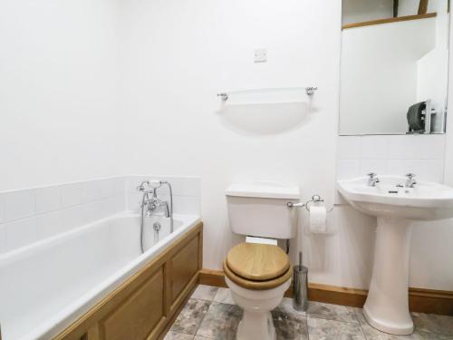 桑德巴奇High Trees的浴室配有卫生间、盥洗盆和浴缸。