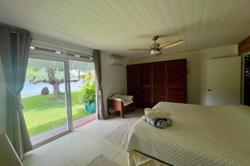 OtumaiVilla Ohana - Deluxe Villa w Private Beachfront的一间卧室设有一张床和一个大型滑动玻璃门