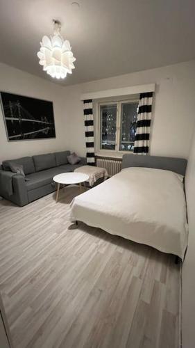赫尔辛基Kallion helmi的卧室配有白色的床和沙发