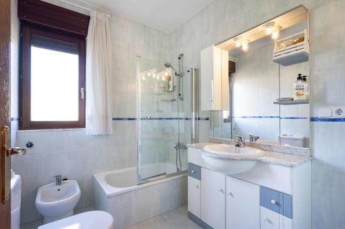 纳韦斯Llanes Asturias的一间带两个盥洗盆、淋浴和卫生间的浴室