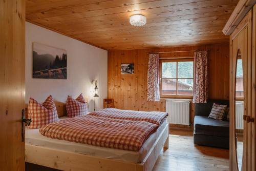 BodenBergbauernhof Pabulariu的一间卧室配有一张床、一张沙发和一个窗口