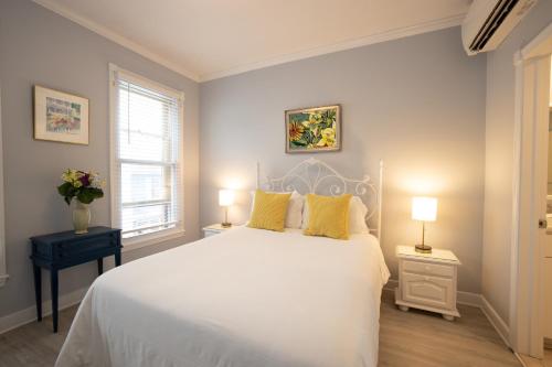 安纳波利斯Inn on Main Annapolis的卧室配有一张带黄色枕头的大型白色床。
