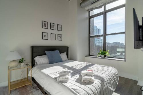 芝加哥McCormick Place beautiful 2b-2b apartment with optional parking - sleeps up to 6的一间卧室配有一张大床和毛巾