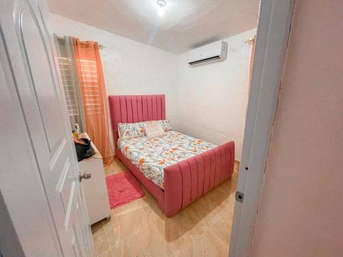 Villa IsabelaAcogedora casa de 2 habitaciones的一间小卧室,卧室内配有粉红色的床