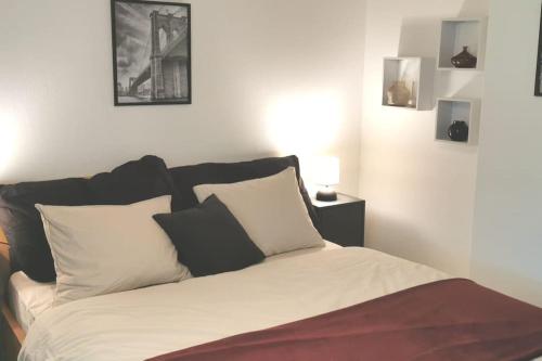 JenazSchönes kleines Studio mit Sitzplatz, mitten im Prättigau的卧室内的一张带黑白枕头的床
