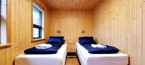 TalknafjordurDixon Cabin nr. 7 / Dixon sumarhús nr. 7 @Kirkjubraut的配有两张床铺的蓝色和白色枕头