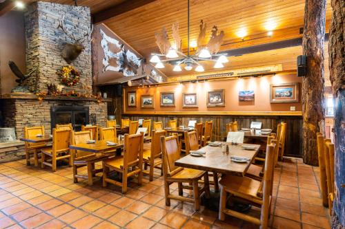 摩押赤壁小屋酒店的餐厅设有木桌、椅子和壁炉