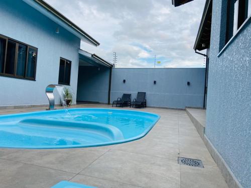 伊瓜苏Casa Privativa na Av. Garibaldi Vila A的大楼一侧的大型蓝色游泳池