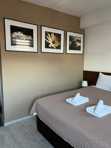 普里莱普Deni Apartments的卧室配有一张墙上三幅照片的床