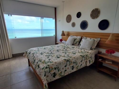 巴伊亚福尔莫萨A CASA FORMOSA的一间卧室设有一张床,享有海景