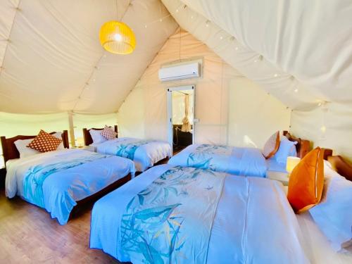 仁爱乡見晴花園山莊Sunshine Villa的帐篷内带三张床的房间