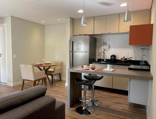 圣保罗415 - Rentaqui - Flat Jardins Residence Confort的厨房配有柜台、桌子和冰箱。