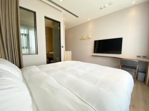 大园区艾尔芙公园行旅的卧室配有一张白色大床和一台平面电视。