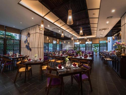 河内Muse Hanoi PentStudio West Lake的餐厅设有木桌、椅子和窗户。