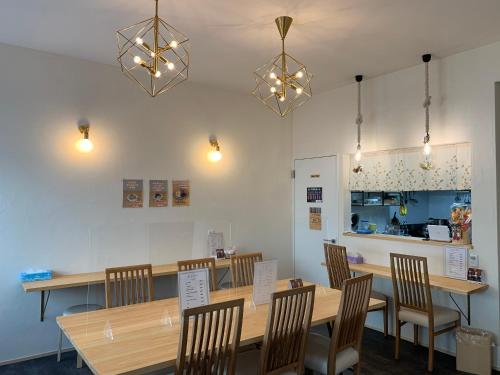 熊野市Oninosanpomichi的用餐室配有木桌、椅子和灯