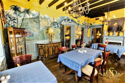 圣奥古斯丁Casa De Solana Bed and Breakfast的用餐室配有桌椅和壁画