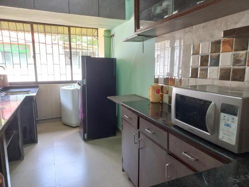 帕纳吉2 Bhk Holiday home near Panjim city & Beaches的厨房配有冰箱和微波炉