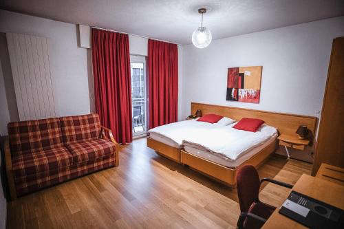 锡永精英酒店的一间卧室配有一张床、一张沙发和一个窗口
