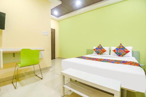 海得拉巴FabExpress Airport Stay Inn的卧室配有白色的床和绿色椅子