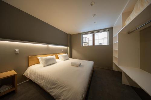 白马村Bluebird Apartments by The Hakuba Collection的卧室配有白色的床和窗户