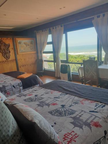 阿曼济姆托蒂深蓝旅馆的一间带两张床的卧室,享有海景