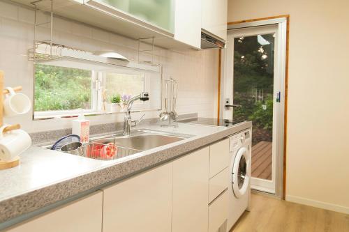 西归浦市Bandi House的厨房配有水槽和洗衣机