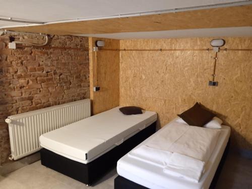 比勒费尔德#HANDWERKER_Rustikal Cityapartment Bielefeld Mitte的砖墙客房的两张床