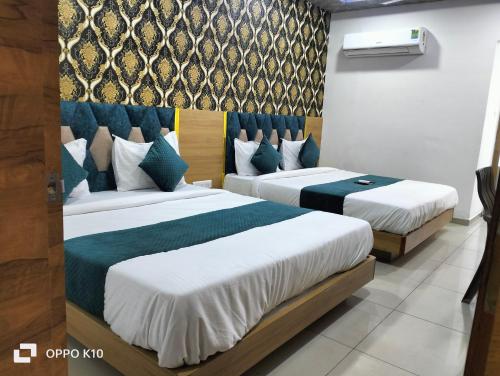 阿南德hotel rudra palace的两张位于酒店客房的床,配有两张sidx sidx单人床