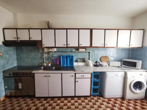 PoiaresO Mercadinho的厨房配有白色橱柜和洗衣机。