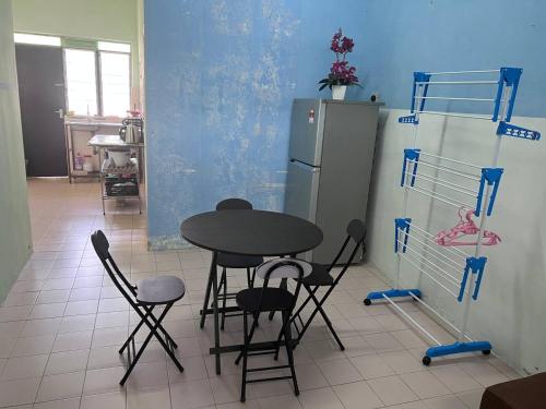 宜力Maju Homestay的厨房配有桌椅和冰箱。