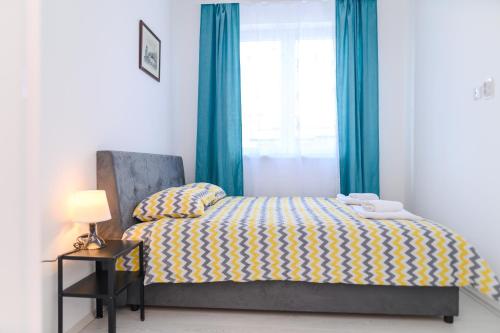索科矿泉村Apartman MASTER的一间卧室配有一张带蓝色窗帘的床和一扇窗户
