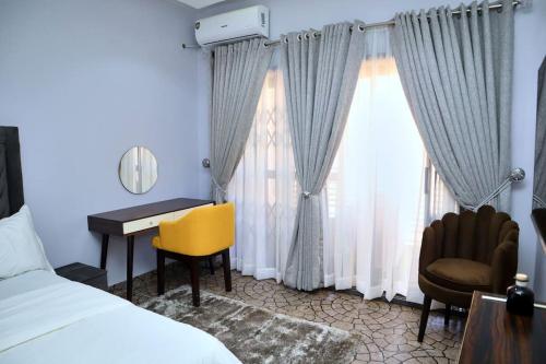 KarsanaLush Meadows Apartments的配有一张床、一张书桌和一扇窗户的酒店客房