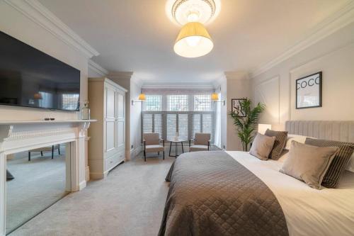 哈罗盖特Westcourt by RMG Apartments的卧室配有床、书桌和钢琴