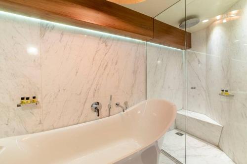 哈罗盖特Westcourt by RMG Apartments的白色的浴室设有浴缸和淋浴。