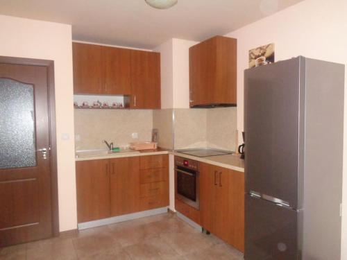 瓦尔纳Home Relax Varna的厨房配有木制橱柜和不锈钢冰箱。