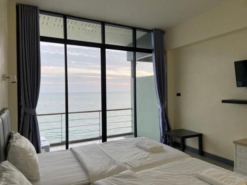 Phala Shore Resort的一间卧室配有一张床,享有海景